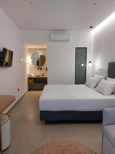 a white bedroom with a bed and a bathroom at Anastasia Apartments in Balíon