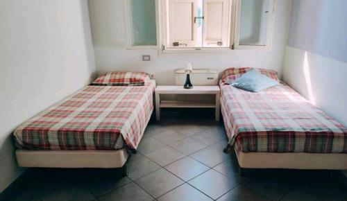 2 camas individuais num quarto com uma janela em La *Bastia* em Castelfranco Emilia