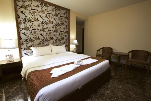 Una habitación de hotel con una cama con toallas. en Katesiree House, en Pattaya central
