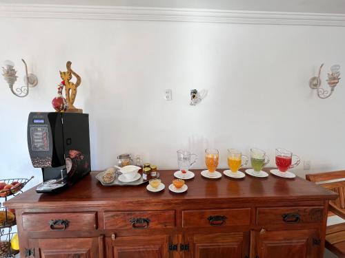 una mesa con copas y vasos encima en Pousada Tiradentes, en Tiradentes