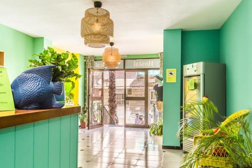 アルムニェーカルにあるHostal Tropicalの緑と青の壁と植物のあるロビー