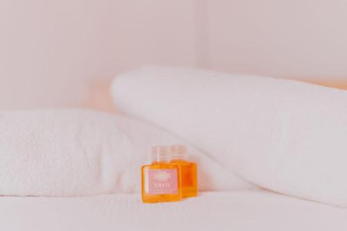 een fles sinaasappelzeep zittend op een bed bij Hotel Masam Isla Mujeres in Isla Mujeres