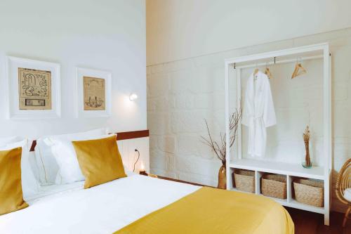 a bedroom with a yellow and white bed and a window at Oliveiras Village — Agroturismo in Amarante