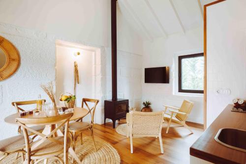 a living room with a table and chairs and a stove at Oliveiras Village — Agroturismo in Amarante
