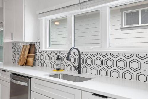 uma cozinha branca com um lavatório e uma janela em Gorgeous Downtown Bungalow em Coeur d'Alene