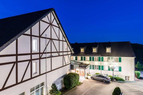 a building with a car parked in front of it at Waldhotel Eskeshof in Wuppertal