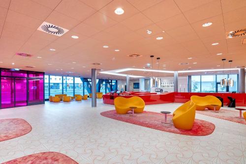 a lobby with yellow and red furniture in a building at prizeotel Vienna-City in Vienna