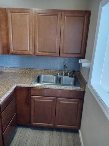 a kitchen with wooden cabinets and a sink at FairBridge Inn & Suites Richmond Hill in Richmond Hill