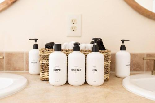 a group of five shampoo bottles sitting on a bathroom counter at Hemingway House - Hot Tub Under The Desert Stars in Yucca Valley
