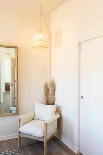 a white chair in a room with a mirror at Hemingway House - Hot Tub Under The Desert Stars in Yucca Valley