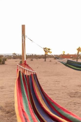 a hammock on a beach with a desert at Hemingway House - Hot Tub Under The Desert Stars in Yucca Valley