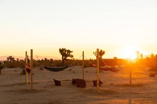 a hammock in the desert with the sunset in the background at Hemingway House - Hot Tub Under The Desert Stars in Yucca Valley
