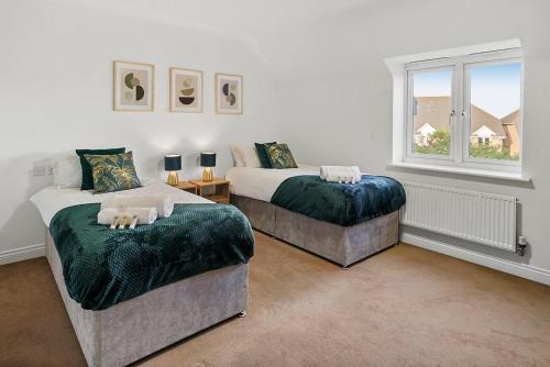 1 Schlafzimmer mit 2 Betten und einem Fenster in der Unterkunft Townhouse in Dartford sleeps 8 with free parking in Dartford