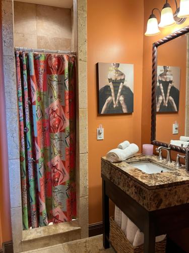 a bathroom with a shower curtain and a sink at Private Oceanfront Escape: Kayaks, Sunsets, Coral! 