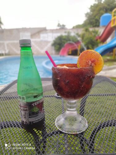 un drink con un'arancia e una bottiglia di soda di Hotel los Abuelos a Jojutla de Juárez