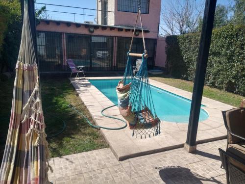 a pair of hammocks next to a swimming pool at EDU'S HOUSE i in Guaymallen