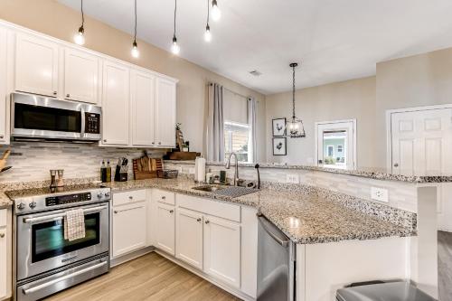 a kitchen with white cabinets and stainless steel appliances at Flat Rock Flat in Port Wentworth