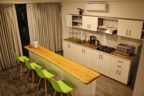 una cocina con encimera y algunas sillas verdes en Las Hamacas Hotel, en Sauce