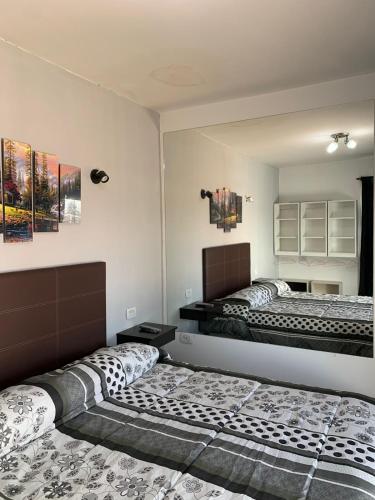 two beds in a room with two bedsitures at EDU's HOUSE I in Guaymallen