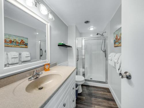 a white bathroom with a sink and a shower at Sand & Sea: Beach Dreams (112) in Seaside