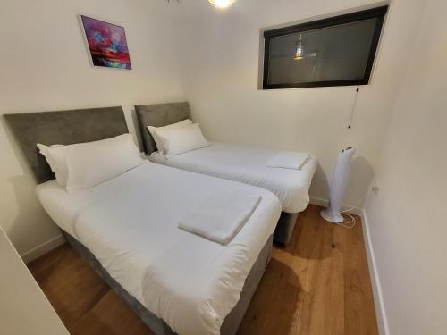 two beds in a small room with a tv at City Centre Stylish Apartment Croydon-Free Parking Provided in Croydon