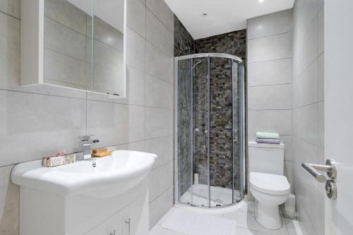 a bathroom with a shower and a sink and a toilet at City Sparrow Apartment Pad -1 in London