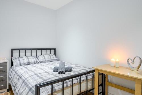 a bedroom with a bed and a table with two candles at City Sparrow Apartment Pad -1 in London