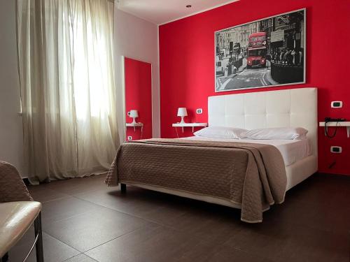 1 dormitorio rojo con 1 cama con pared roja en Hotel Glem, en Varcaturo