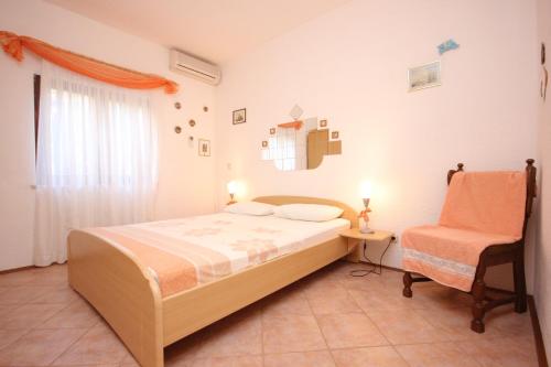a bedroom with a bed and a chair at Apartments by the sea Okrug Gornji, Ciovo - 8441 in Trogir
