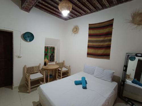 um quarto com uma cama, uma mesa e cadeiras em Terrace House 88 em Marrakech