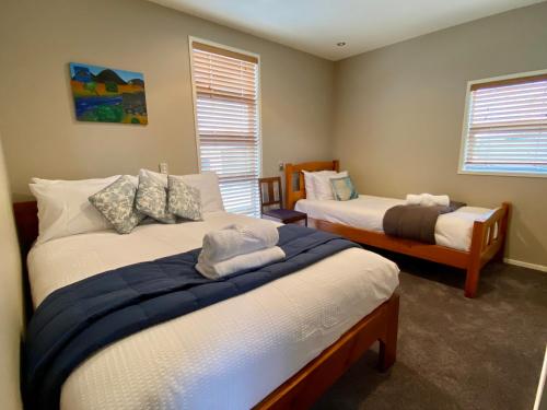 a bedroom with two beds and two windows at All Year Getaway in Twizel