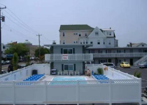 a house with a swimming pool in front of a building at Sunbeach Condo 900 Wesley Avenue Unit 109 in Ocean City