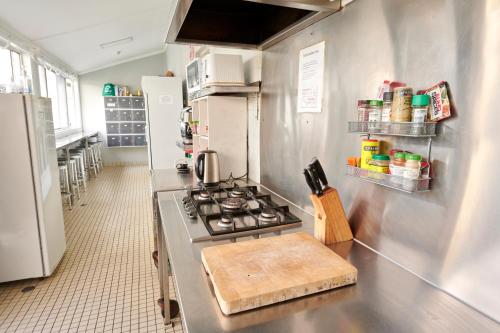 a kitchen with a stove and a refrigerator at PodBed Coogee Beachside in Sydney