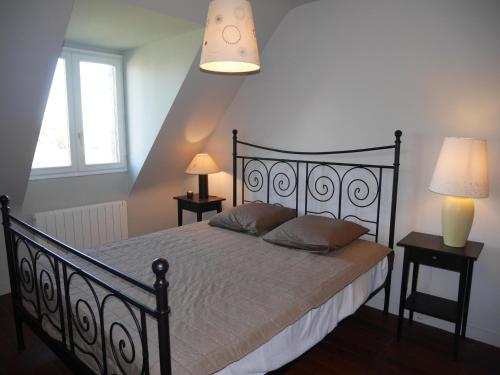 - une chambre avec un lit noir, deux tables et deux lampes dans l'établissement Cottage, Guisseny, à Guissény