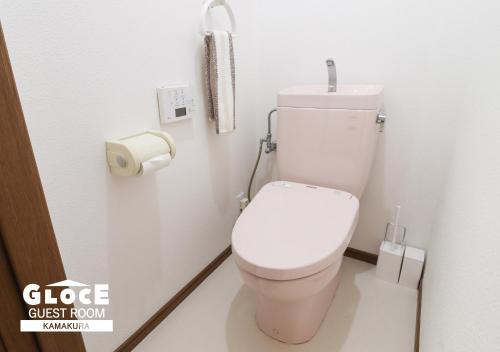 a bathroom with a toilet with a phone on the wall at GLOCE 鎌倉 若宮大路House お部屋から江ノ電ビューを独り占め 鎌倉駅から徒歩3分 in Kamakura