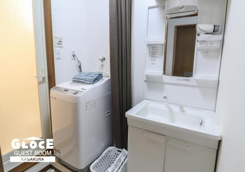 a bathroom with a sink and a washing machine at GLOCE 鎌倉 若宮大路House お部屋から江ノ電ビューを独り占め 鎌倉駅から徒歩3分 in Kamakura