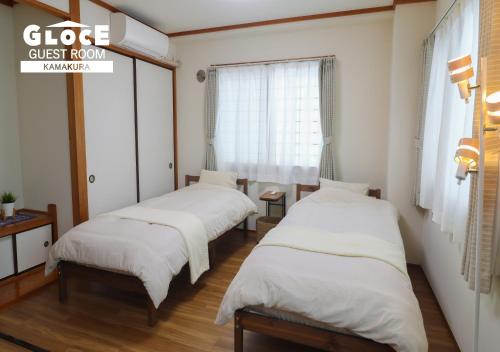 a group of three beds in a room at GLOCE 鎌倉 若宮大路House お部屋から江ノ電ビューを独り占め 鎌倉駅から徒歩3分 in Kamakura
