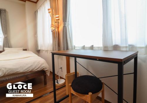 a desk in a room with a bed and a chair at GLOCE 鎌倉 若宮大路House お部屋から江ノ電ビューを独り占め 鎌倉駅から徒歩3分 in Kamakura