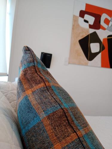 a blanket sitting on top of a couch next to a painting at Hotel Posada de Santa Elena in Tunja