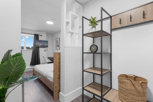 a bedroom with a bed and a black book shelf at Le Sand & Stone Hotel in Montréal