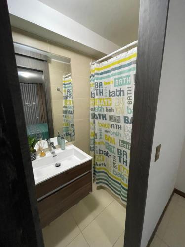 a bathroom with a sink and a shower curtain at Fantástico departamento a pasos de playa cavancha con estacionamiento in Iquique