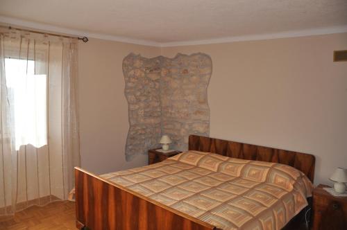 ein Schlafzimmer mit einem Bett und einem Fenster in der Unterkunft Apartments with a parking space Rakalj, Marcana - 15250 in Krnica
