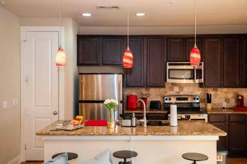 una cucina con armadi marroni e un bancone con sgabelli di Gorgeous Apartment. Montrose / Downtown a Houston