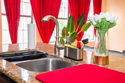 un bancone della cucina con lavandino e vaso di fiori bianchi di Gorgeous Apartment. Montrose / Downtown a Houston