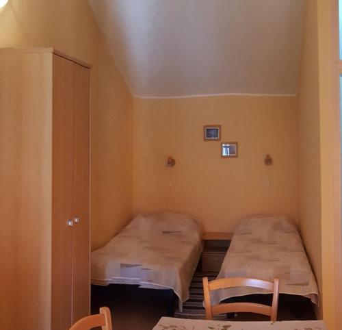 ein kleines Zimmer mit zwei Betten und zwei Stühlen in der Unterkunft Apartments with a parking space Rakalj, Marcana - 15252 in Krnica