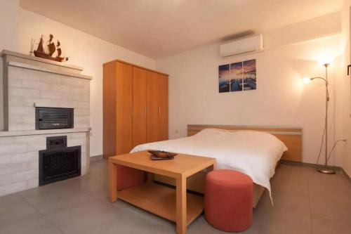 een slaapkamer met een bed, een tafel en een open haard bij Apartments with a parking space Stinjan, Pula - 15256 in Pula