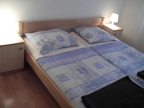 a bed in a bedroom with two pillows on it at Apartments with a parking space Pinezici, Krk - 15269 in Vrh