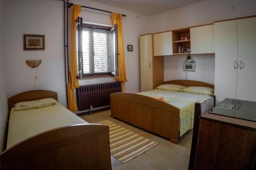 ein kleines Schlafzimmer mit 2 Betten und einem Fenster in der Unterkunft Apartments by the sea Razanj, Rogoznica - 15264 in Rogoznica