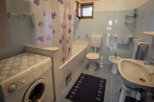 ein Badezimmer mit einer Waschmaschine und einem Waschbecken in der Unterkunft Apartments by the sea Razanj, Rogoznica - 15264 in Rogoznica