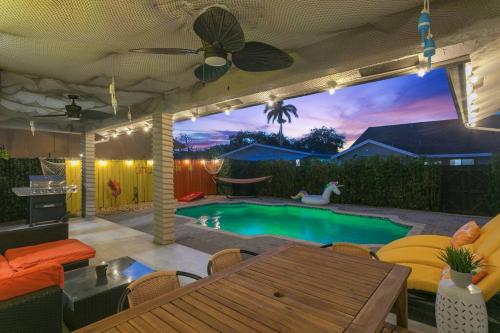 a backyard with a swimming pool with a table and chairs at Citrus+Sunshine/Heated Pool/6 min to Beach/Casino in Dania Beach